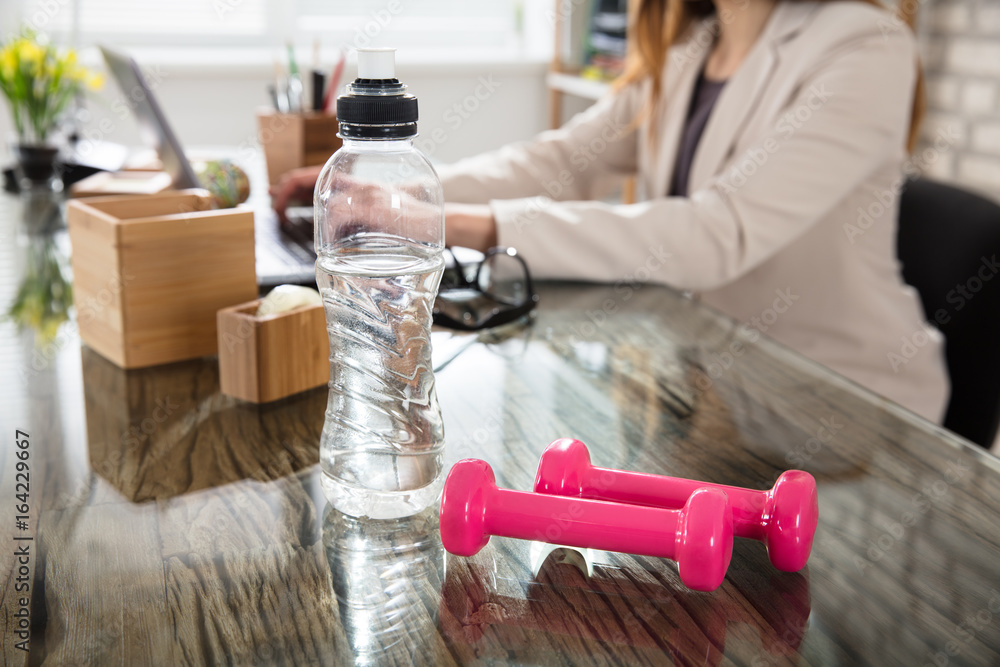 Wall mural water bottle and fitness dumbbells on office desk