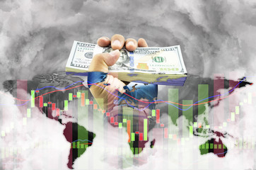 A man hand holding dollars money on smoke and global economic crisis chart, concept of economic confidence