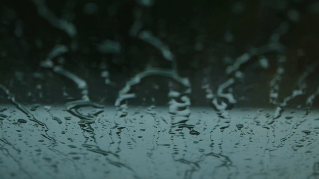 Close up image of rain drops falling on a window