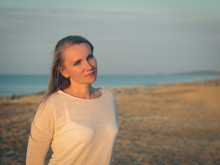 Beautiful woman in white shirt at the evening beach.