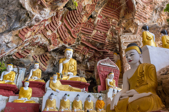 Old temple with Buddhas statues and religious carving on limestone rock in sacred Kaw Goon cave near Hpa-An in Myanmar (Burma)