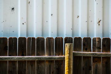 Wooden fence against metal wall