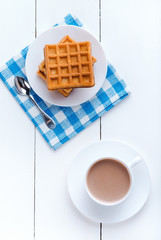 Morning coffee with waffles. Refreshing drink. Wooden board rustic