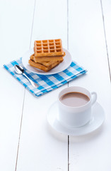 Morning coffee with waffles. Refreshing drink. Wooden board rustic