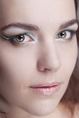 Fototapeta premium Close-up portrait of girl with clean skin and bright makeup. Demonstration of makeup cat eyes.