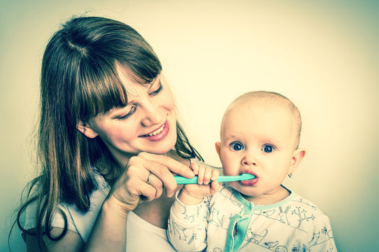 Mother and her baby brushing teeth together - retro style