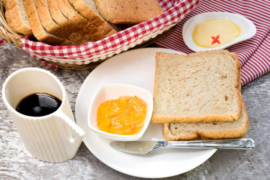 Toasted bread with fruit jam and coffee cup