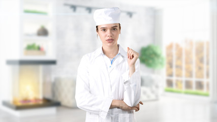 Beautiful medical woman doctor in uniform. Studio painted background. Concept of profitable health care.