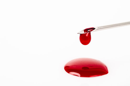 Macro View Of Drop Of Blood From Needle Syringe.