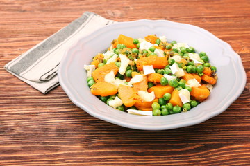 Warm salad with roasted pumpkin, peas and cheese brie