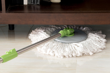 cleaning floor with mop under Shelves