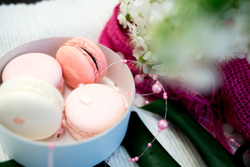 Tender macaroons in a white pile and clocks on white background