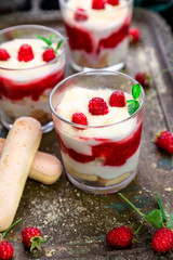 Tiramisu with raspberry in glasses on metal tray. Three portion. Italian dessert.