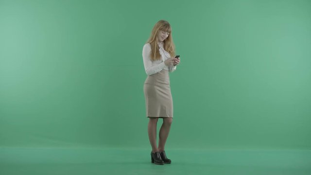 a smiling woman holds a smartphone in hands