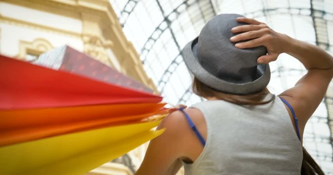 Beautiful young tourist girl (woman) in Milan, shopping, wearing a hat, new clothes, happy smiling, background Milan gallery. Concept: tourism, love travel, communication, freedom, love life, shopping