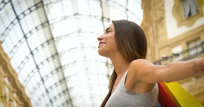 Portrait of a beautiful young tourist girl (woman) in Milan, feels free, happy smiling, background Milan gallery. Concept: tourism, love to travel, communication, freedom, love life, lifestyle, people