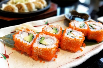 Ebiko maki sushi rolls - japanese food style in a ceramic plate.