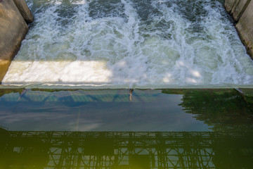 Stream flowing through a weir in sunlight
