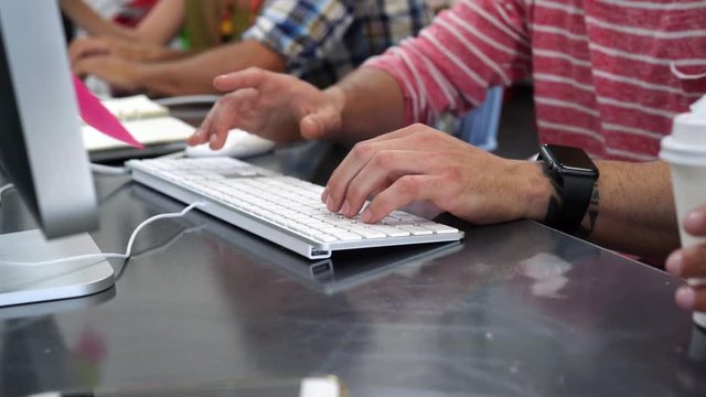 Closeup of hands typing on desktop keyboard