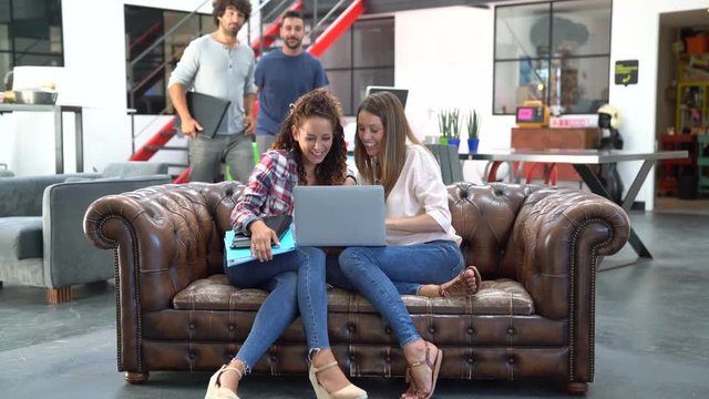 Group of trendy people sitting in office lounge couch