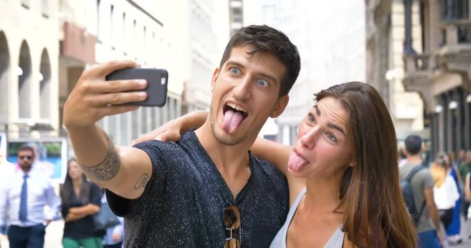 Young beautiful guy and girl doing selfie in the phone, happy smiling, in the Milan. Concept: tourism, love to travel, freedom, love life, lifestyle, people, big city, communication, best friends.