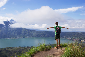 A man enjoys volcano lake view with clouds blue sky