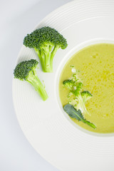 Cream of soup and inflorescences of broccoli close-up in a white plate..