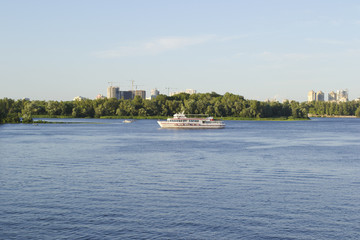 Naklejka premium The boat sails slowly along the river