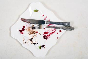 Empty white plate with crumbs and cream after eating © katrin_timoff