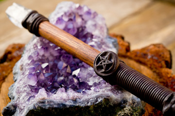Cleansing and charging wiccan wand, with pentagram - pentacle symbol, on amethyst crystal geode