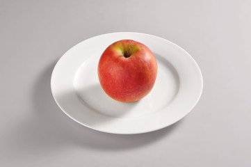 Round dish with a red apple