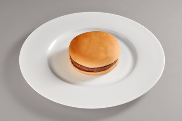 Round dish with a simple sandwich cheeseburgher