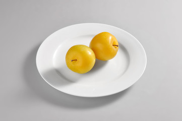 Round dish with two plums