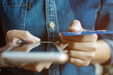 Close up hand of woman holding the blank screen of moblie phone and credit card to pay the product shopping online