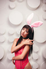 Obraz na płótnie Canvas Beautiful slim model woman in pink sexy lingerie with bunny