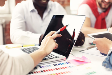 Teamwork,brainstorming concept.Young creative managers team working with new startup project in modern office. Contemporary notebook on wood table.Horizontal