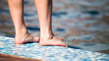 Feet of the girl near the pool