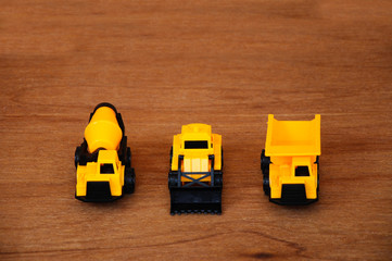 Group of small heavy construction machine toy, lorry, bulldozer and concrete mixer. All made of...