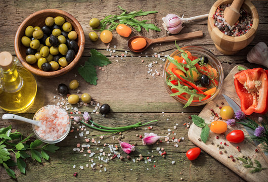 vegetables and olives on old wooden background