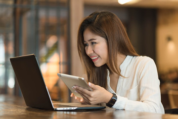 Woman use tablet and laptop in coffee shop