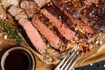 Beef rump steak from marble beef medium rare with sauce on wood plate, close-up. Selective focus.