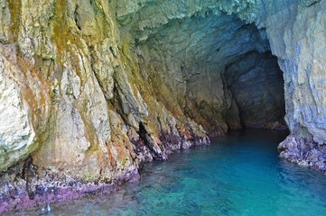 Green grotto with colourful walls and emerald water