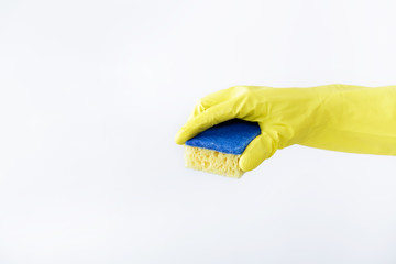 hand in rubber yellow glove holding sponge on white background. cleaning