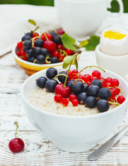 healthy breakfast - oatmeal with fresh berries in a bowl on white, fresh berries on the street
