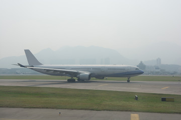 The airplane is running on Taxi way in Hong Kong International airport during dense fog weather.