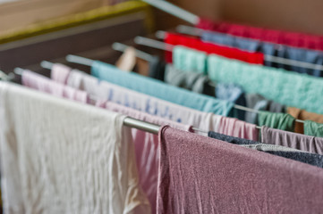 Wet colorful underwear hanging and drying in the apartment on the dryer