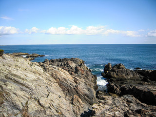 Felsformationen mit Bick über den Nordatlantik nahe Ogunquit mit einigen Wolken über dem blauen Horizont