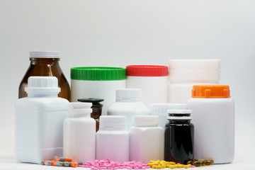 Pills and bottles with cap on white background