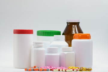 Pills and bottles with cap on white background