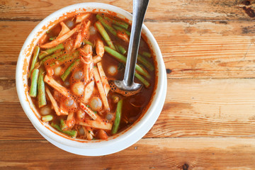 Thai cuisine spicy curry soup with vegetable and eggs of giant sea catfish on wooden table